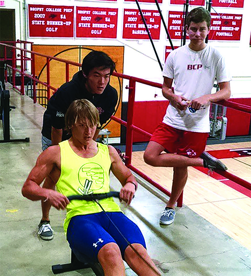 Photo provided by Brophy Crew Instagram -- Chase Hoyt 15 practices on an erg as teammate Brian Loh 15 watches.
