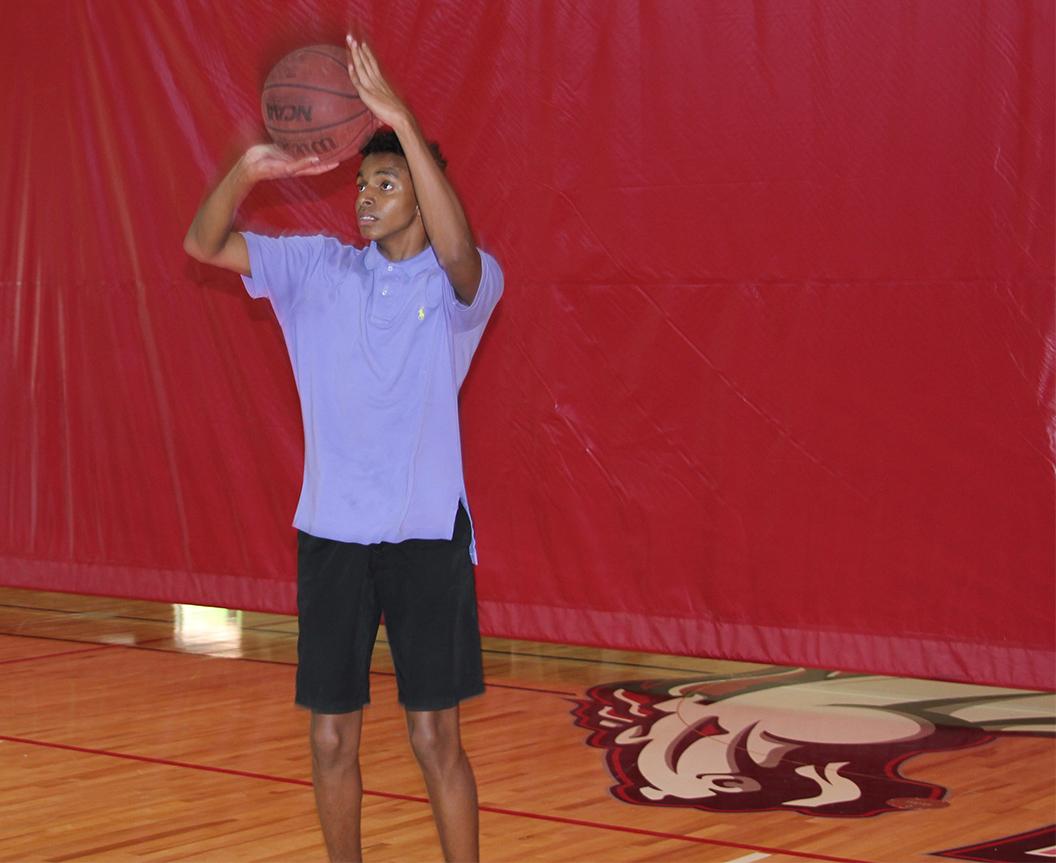 Photo by Edwin Perez ’18 | Edwin Mehari ’18 shoots a basketball during a flex period Apr. 4. Students find inclusive community through playing basketball in the Dutch.