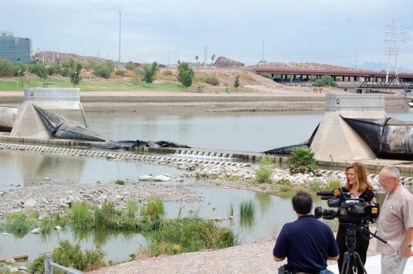Photo by Carter Radcliffe '11 - A media crew reports on a dam burst at Tempe Town Lake that left the lake empty and Brophy's crew team with their regular practice water.