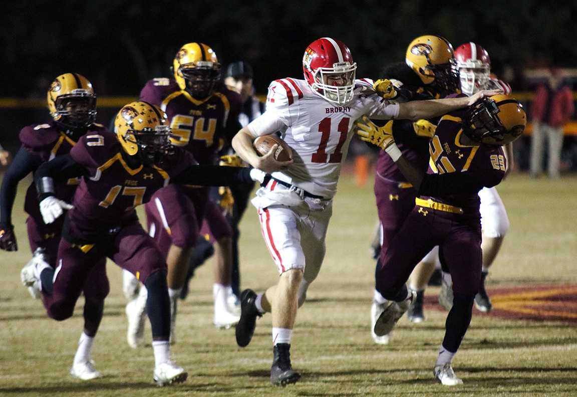 Photo by Bryce Owen 17 | Cade Knox ’16 stiff arms a Mountain Pointe defender Nov. 13 while running the ball. Brophy lost to Mountain Pointe 35-31 in the quarter final round of the 2015 state football playoffs.