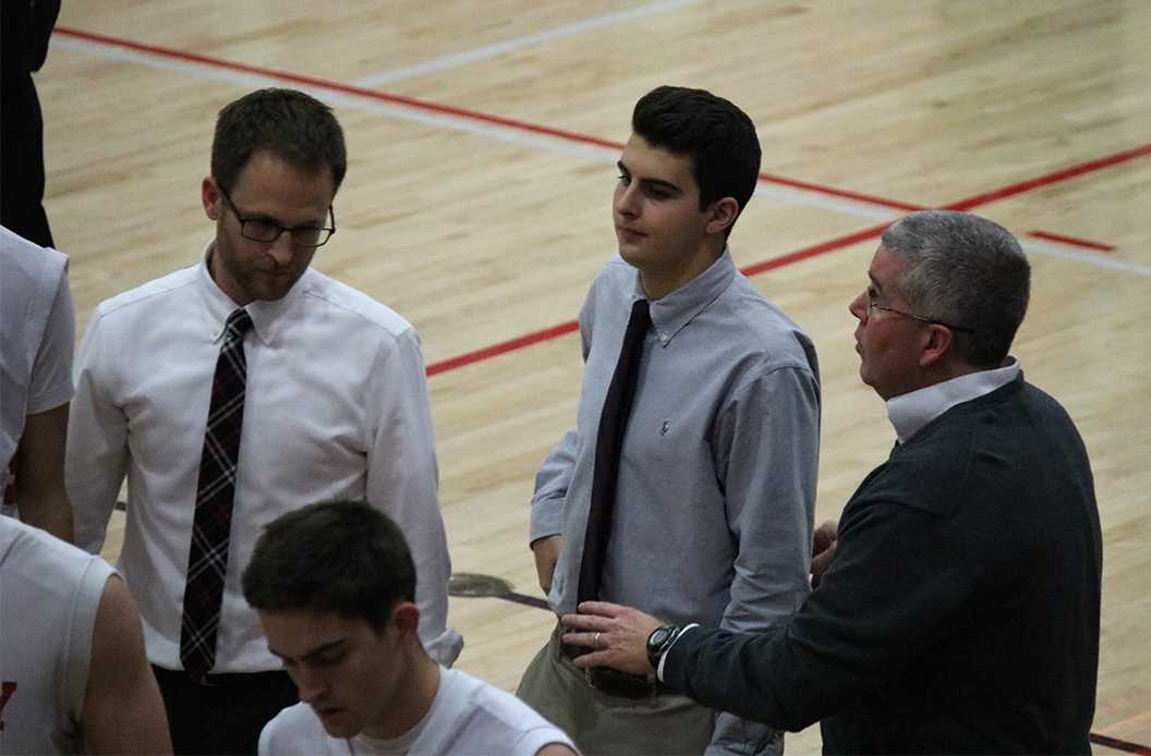 Photo by Bryce Owen ’17 - John Zacher ’17 heads to the team huddle as a timeout is called. Zacher has managed for the basketball teams since his freshman year.