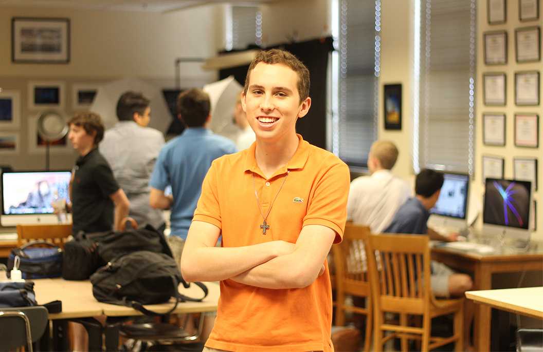 Photo by Cory Wyman ’16 - Outgoing Co-Editor In Chief Cameron Bray ’16 poses for a photo in Mr. Mulloy’s room as the Roundup staff works in the background.