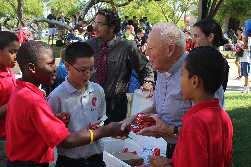 Photo by Luis Gamez ’15 | Fr. Harry “Dutch” Olivier hands out ice cream to Loyola Academcy students at break Sept. 4, 2012.
