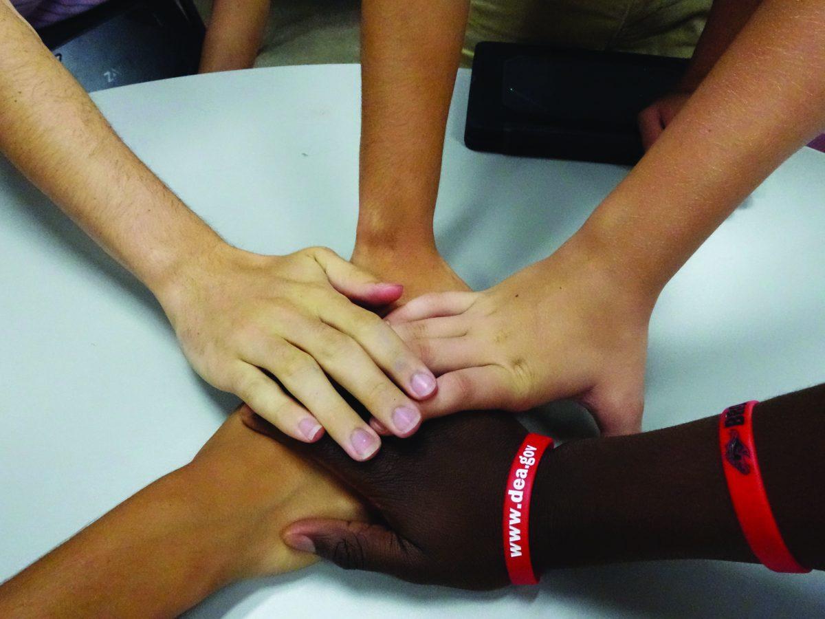 Photo By Edwin Perez 18 | Students touch each others hands to show the diversity on campus.