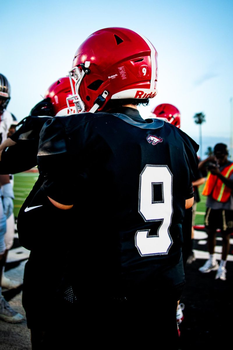 Ryder Noche ’27 watches the coin toss before a game.